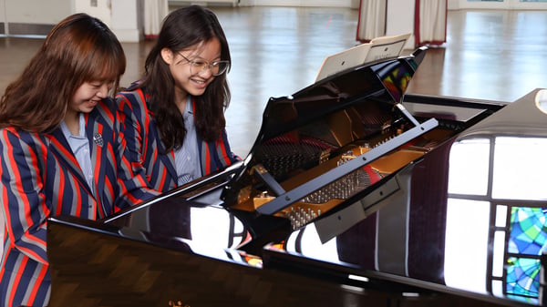 Zwei Schülerinnen spielen gemeinsam am Klavier auf dem Campus des Bishopstrow College.