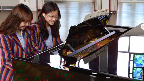 Zwei Schülerinnen spielen gemeinsam am Klavier auf dem Campus des Bishopstrow College.