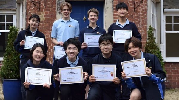 Eine Gruppe Schüler hält vor dem Backsteingebäude des Bishopstrow College ihre Zertifikate und Auszeichnungen.
