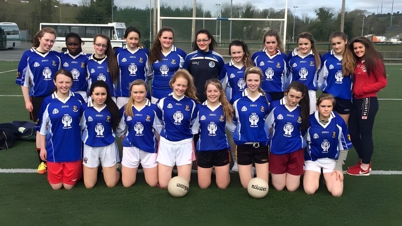 Eine Gruppe junger Fußballspielerinnen posiert auf dem Sportplatz der Blackwater Community School.