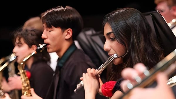 Eine Gruppe von Musikern spielt auf der Bühne der Blair Academy verschiedene Instrumente.