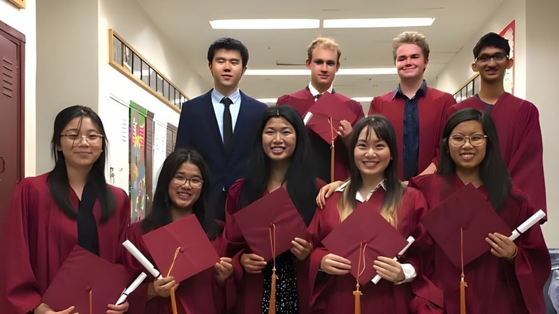 Schülerinnen und Schüler des Bloor Collegiate Institute stehen in ihren Abschlussgewändern gemeinsam im Flur.