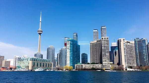 Eine Skyline moderner Wolkenkratzer mit einem markanten Turm spiegelt sich im Wasser nahe dem Bloor Collegiate Institute.