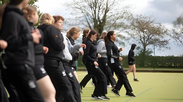 Eine Gruppe von Schülerinnen und Schülern der Bloxham School steht auf einem Grasfeld vor Bäumen.