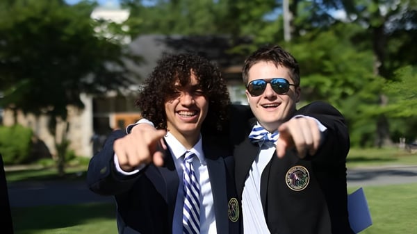 Zwei Schüler der Blue Ridge School stehen im Freien vor Bäumen und lächeln in die Kamera.