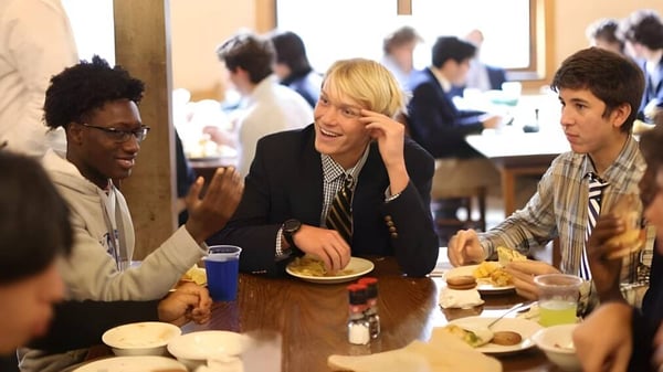 Schüler der Blue Ridge School sitzen in einem Speisesaal zusammen und unterhalten sich während sie eine Mahlzeit teilen.