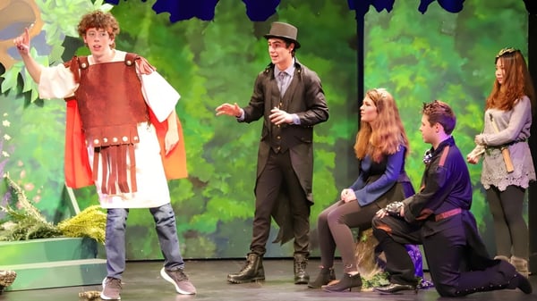 Schüler des Bodmin College stehen in bunten Kostümen in einem grünen Waldumfeld.