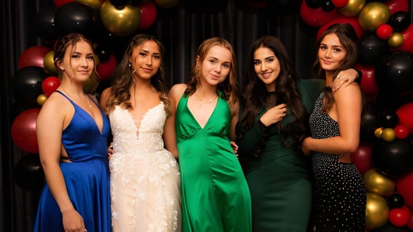 Fünf Schülerinnen des Bodmin College in formeller Kleidung posieren vor einer bunten Ballonwand.