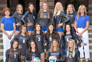 Eine Gruppe junger Athletinnen steht auf der Treppe eines Backsteingebäudes am Boise School District.