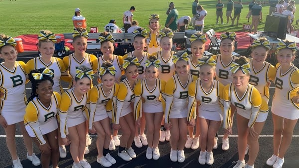 Eine Gruppe junger Athletinnen der Bonneville High School versammelt sich auf einem grünen Spielfeld.