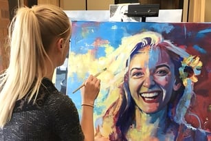 Eine Schülerin der Bonneville High School malt ein farbenfrohes Porträt auf einer Leinwand im Kunstunterricht.