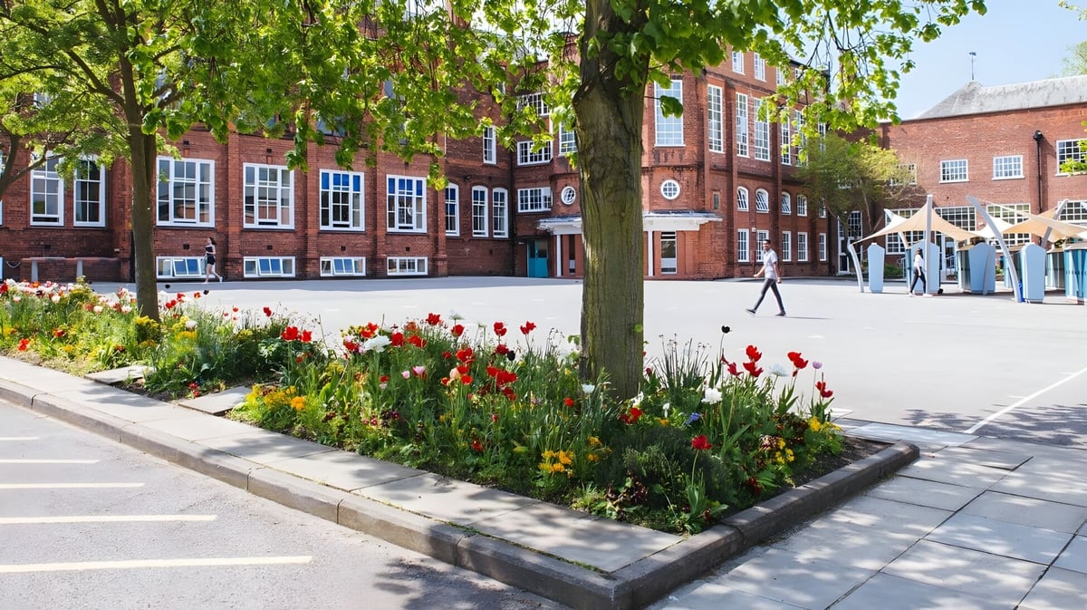 Das Gebäude der Bootham School ist hinter einem Weg mit bunten Tulpen und dichtem Baumdach zu sehen.