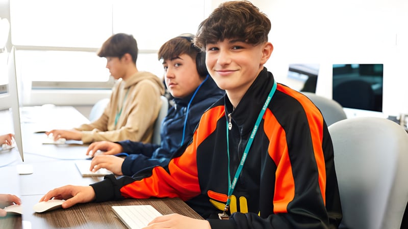 Schüler des Boston College arbeiten gemeinsam an Computern bei einer Bildungsaktivität.