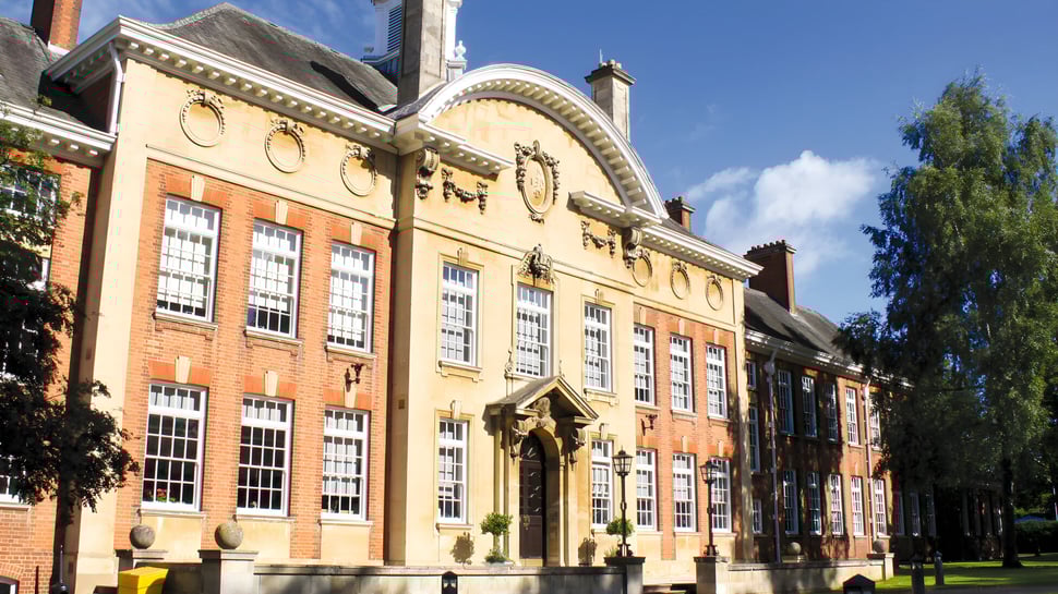 Das prächtige Backsteingebäude des Bosworth Independent College steht umgeben von Bäumen und einem gepflegten Rasen.