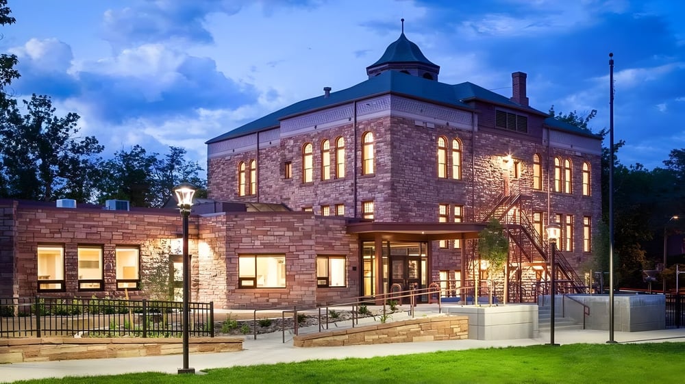 Ein großes steinernes Gebäude mit charakteristischem Turm steht auf dem Campus der Boulder Valley Public Schools.