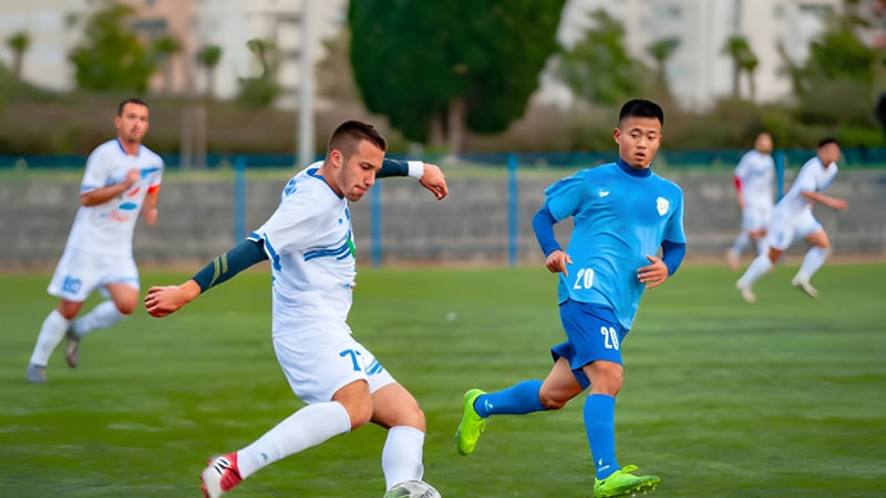 Zwei Schüler spielen Fußball auf dem Sportplatz des Bournemouth & Poole College.