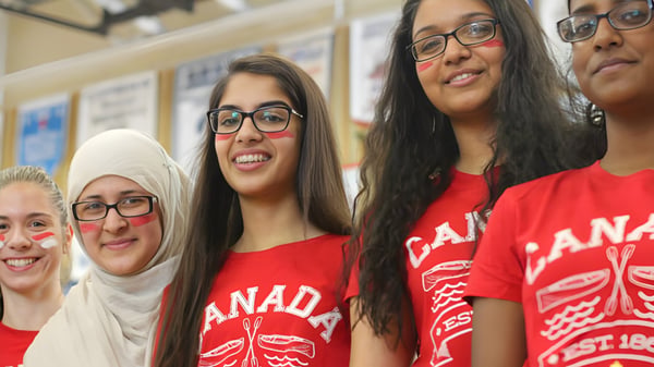 Eine Gruppe junger Frauen in roten Canada-Shirts posiert gemeinsam im Innenraum der Bradford District High School.