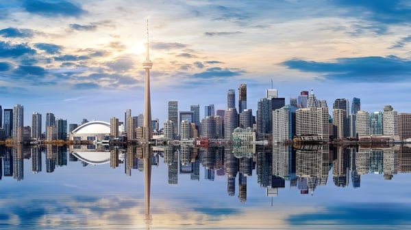 Eine beeindruckende Stadtsilhouette spiegelt sich in ruhigem Wasser unter dramatischem Himmel am Braemar College.