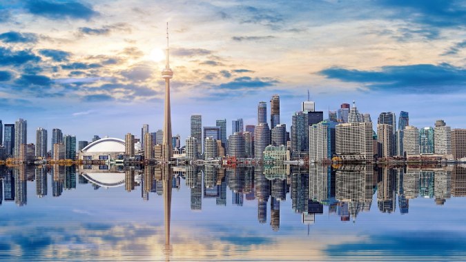 Städtische Skyline mit Wolkenkratzern und Wasserreflexion bei Sonnenlicht nahe dem Braemar College.