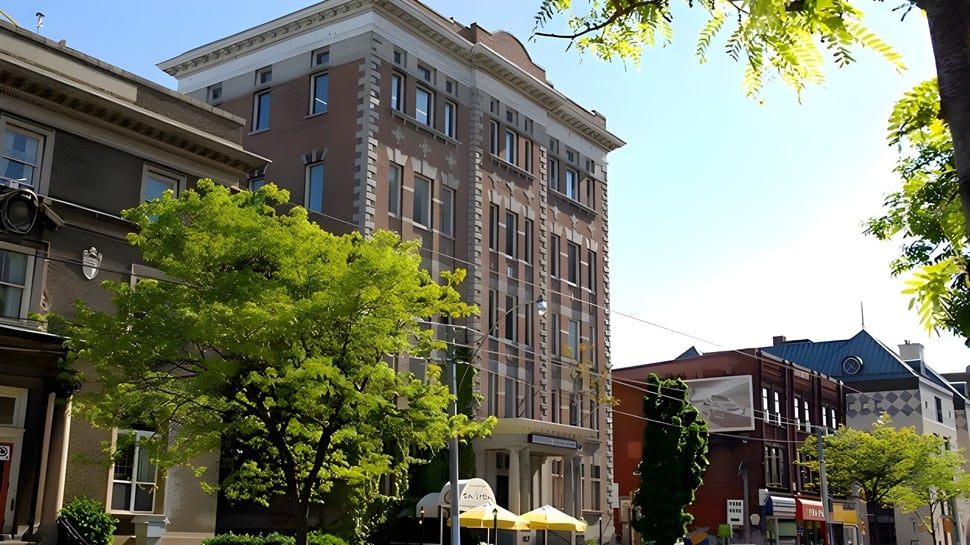 Das mehrstöckige Backsteingebäude des Braemar College steht umgeben von grünen Bäumen in einem lebhaften urbanen Umfeld.