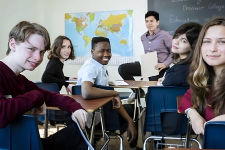 Eine Gruppe vielfältiger Schüler sitzt im Klassenzimmer des Braemar College vor einer Weltkarte.