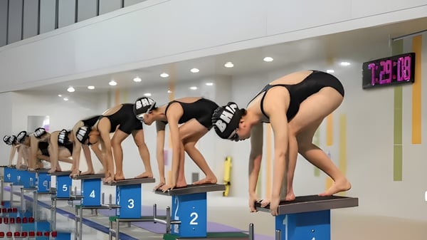 Schülerinnen der Branksome Hall Asia stehen an den Startblöcken im Schwimmbad für einen Wettkampf.