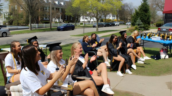 Eine Gruppe junger Studentinnen der Branksome Hall im Freien auf einer Wiese mit Abschlussroben versammelt.