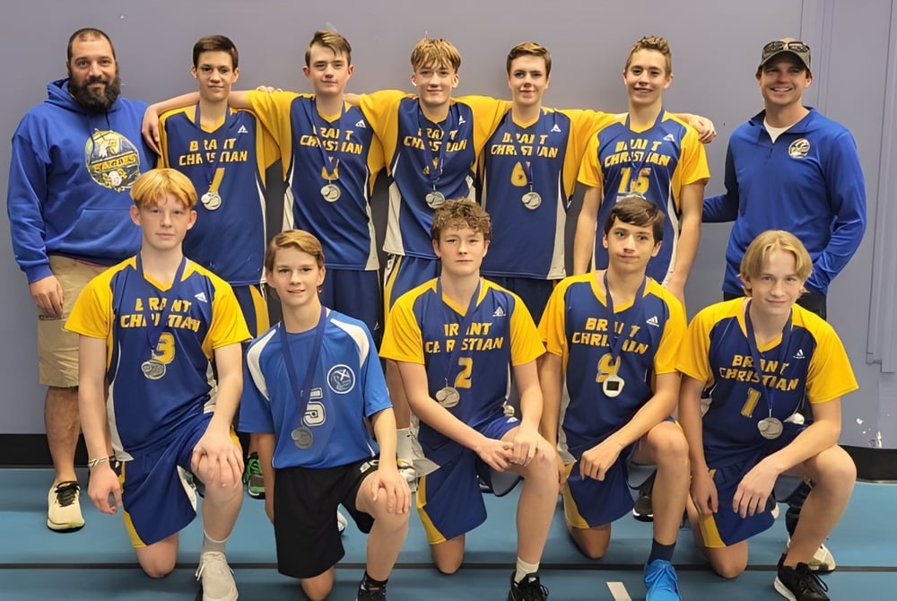 Eine Gruppe von Schülern der Brant Christian School posiert gemeinsam in ihren Basketball-Trikots vor einem einfarbigen Hintergrund.