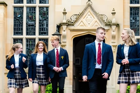 Eine Gruppe Schüler steht vor dem gotischen Gebäude der Bredon School.