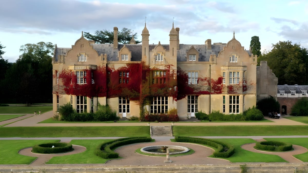 Das Schlossgebäude der Bredon School steht prächtig in einem gepflegten Garten mit einem runden Weg und Hecken.