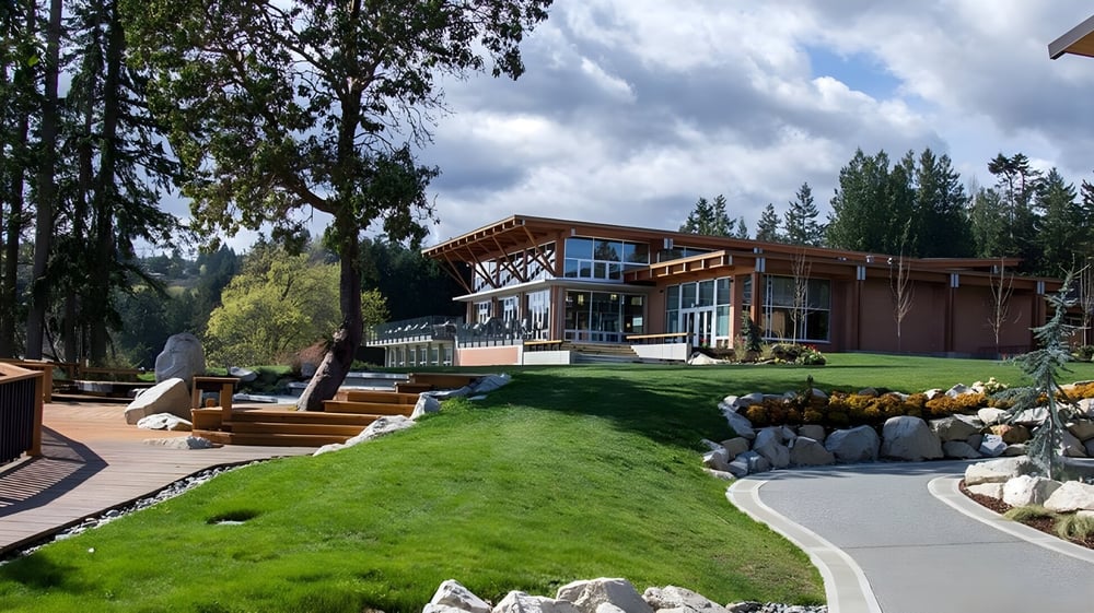 Ein modernes Holzhaus auf dem Gelände der Brentwood College School umgeben von Grünanlagen und einem gepflegten Rasen.