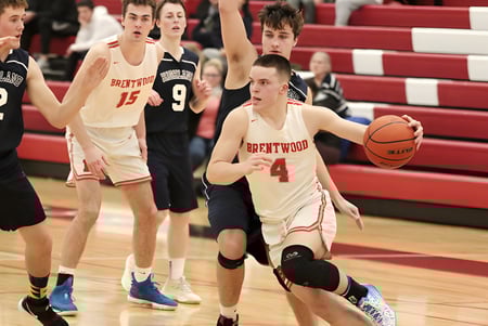 Eine Gruppe Schülerinnen und Schüler spielt Basketball auf dem Spielfeld der Brentwood College School vor Zuschauern.