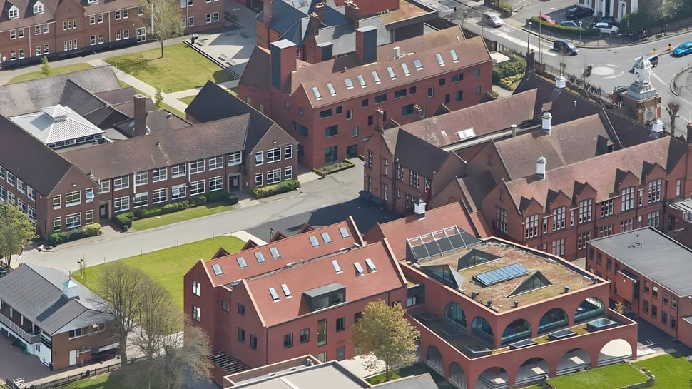 Luftaufnahme des historischen Stadtzentrums mit Backsteinbauten und Grünflächen in der Nähe der Brentwood School.