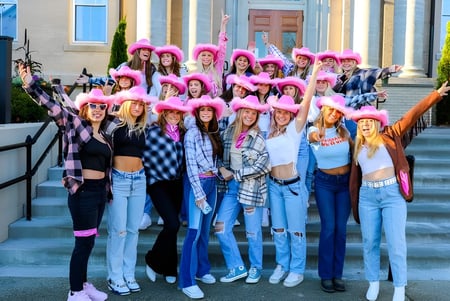 Eine Gruppe Schülerinnen der Brewster Academy sitzt auf den Treppen vor einem Gebäude mit klassischer Architektur.