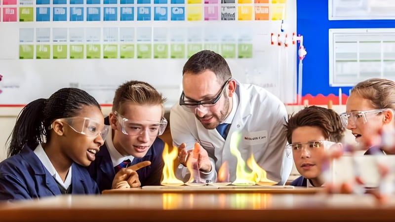 Schülerinnen und Schüler mit einer Lehrkraft führen ein praktisches Wissenschaftsexperiment im Klassenraum des Brighton College durch.