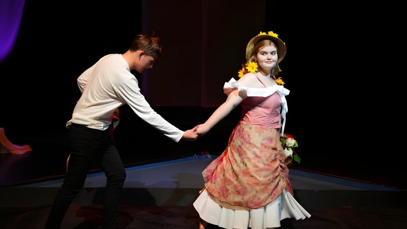 Ein Mann und eine Frau in formeller Kleidung tanzen bei einer Aufführung auf der Bühne der Brighton Secondary School.