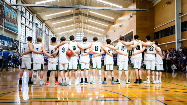Eine Gruppe von Basketballspielern steht gemeinsam auf dem Basketballfeld des Brisbane Boys' College.