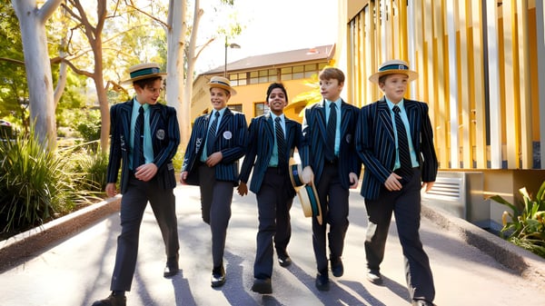 Eine Gruppe Schüler des Brisbane Boys' College geht gemeinsam einen Weg entlang, umgeben von Bäumen und Gebäuden.