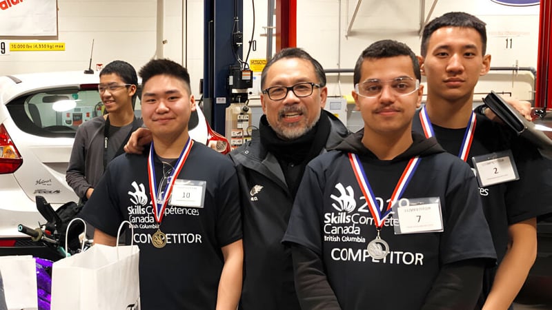 Eine Gruppe von Schülerinnen und Schülern der Britannia Secondary School steht mit schwarzen Shirts im Werkstattbereich.