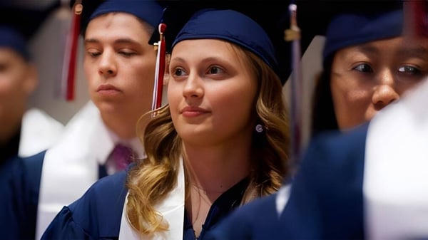 Eine Gruppe von Absolventinnen und Absolventen in blauen Talaren bei der Abschlussfeier der British International School Houston.