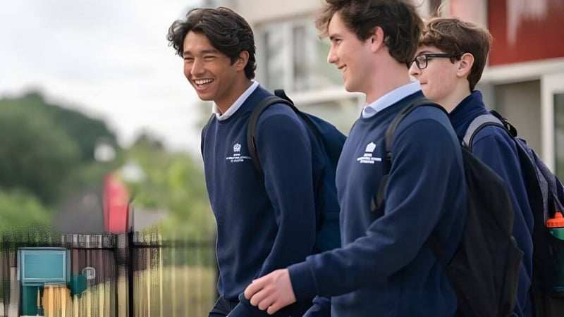Drei Schüler in marineblauen Uniformen stehen im Außenbereich der British International School Houston zusammen und lächeln.