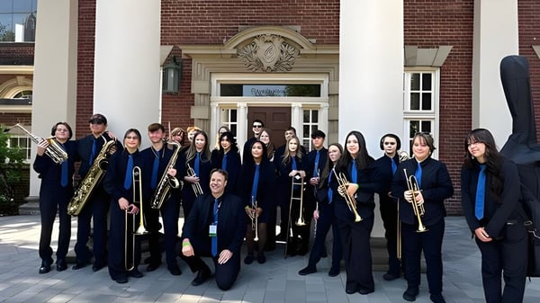 Eine Gruppe von Musikern steht vor dem historischen Gebäude der Brocklehurst Secondary School.