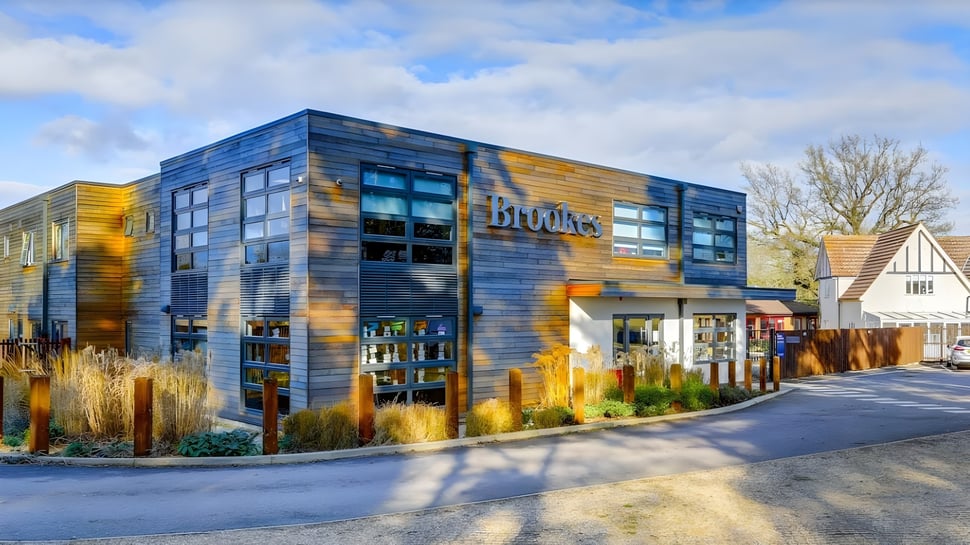 Ein modernes mehrstöckiges Gebäude mit blauen und gelben Fassadenelementen auf dem Campus der Brookes UK.