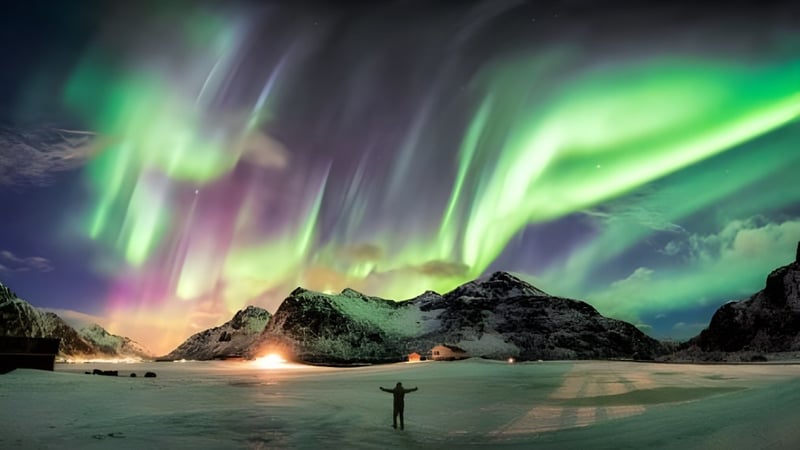 Das Nordlicht erleuchtet den Nachthimmel über einer verschneiten Landschaft mit einer Hütte und einer Person vor der Brookfield High School.