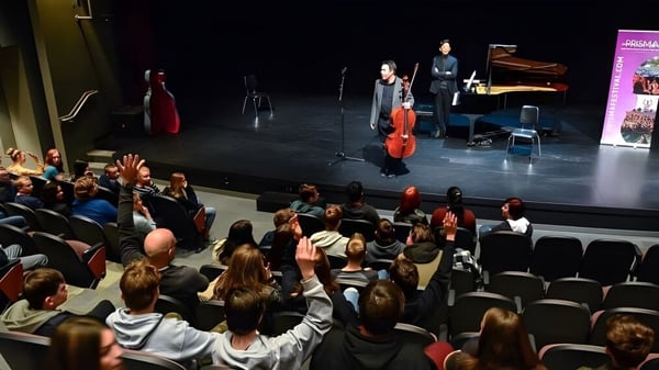 Ein Cellist und ein Pianist der Brooks Secondary School treten auf einer Bühne vor einem sitzenden Publikum auf.