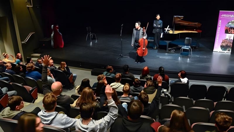 Ein Cellist und ein Pianist der Brooks Secondary School treten auf einer Bühne vor einem sitzenden Publikum auf.