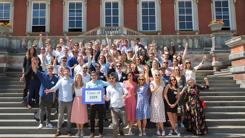 Eine Gruppe von Schülerinnen und Schülern steht vor dem Backsteingebäude der Bryanston School und hält ein Schild mit Class of 2022.