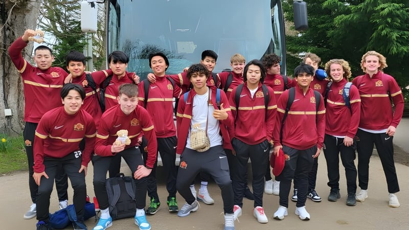 Eine Gruppe von Schülerinnen und Schülern der Buckswood School trägt rote Sportuniformen und posiert gemeinsam im Freien.