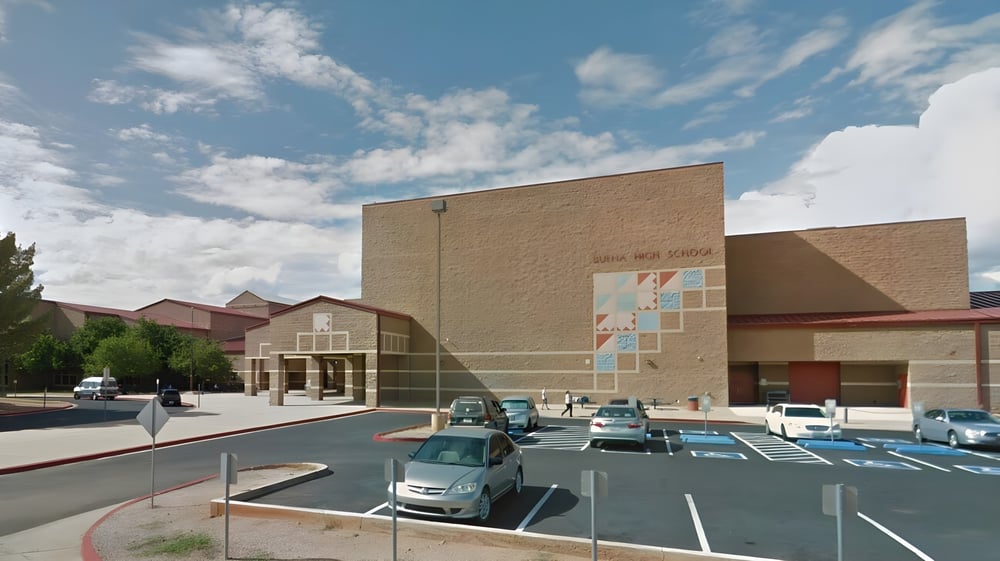 Das Gebäude der Buena High School mit einem Parkplatz im Vordergrund unter blauem Himmel mit Wolken.