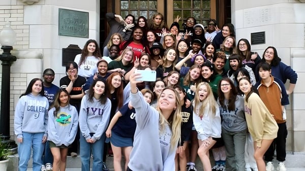 Eine Gruppe von Schülerinnen vor einem Backsteingebäude auf dem Campus der Buffalo Seminary posiert für ein Gruppenfoto.